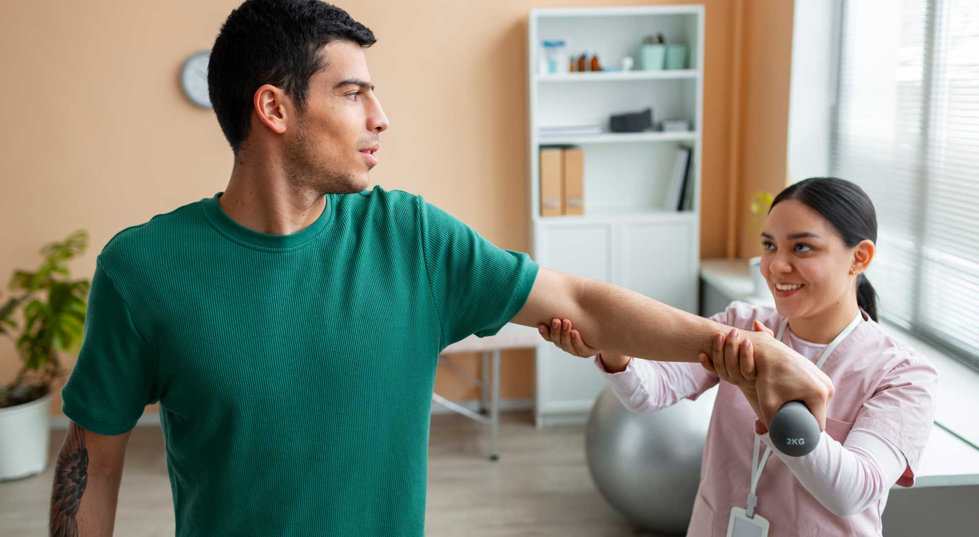 Physiotherapist guiding a patient through a shoulder strengthening exercise